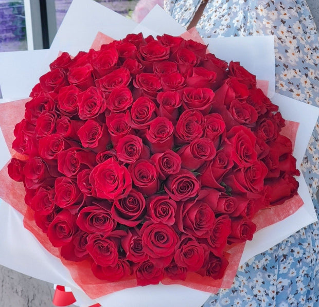 Luxurious bouquet of 101 red roses, showcasing vibrant, velvety petals arranged in a stunning, symmetrical display, symbolizing deep love and passion.