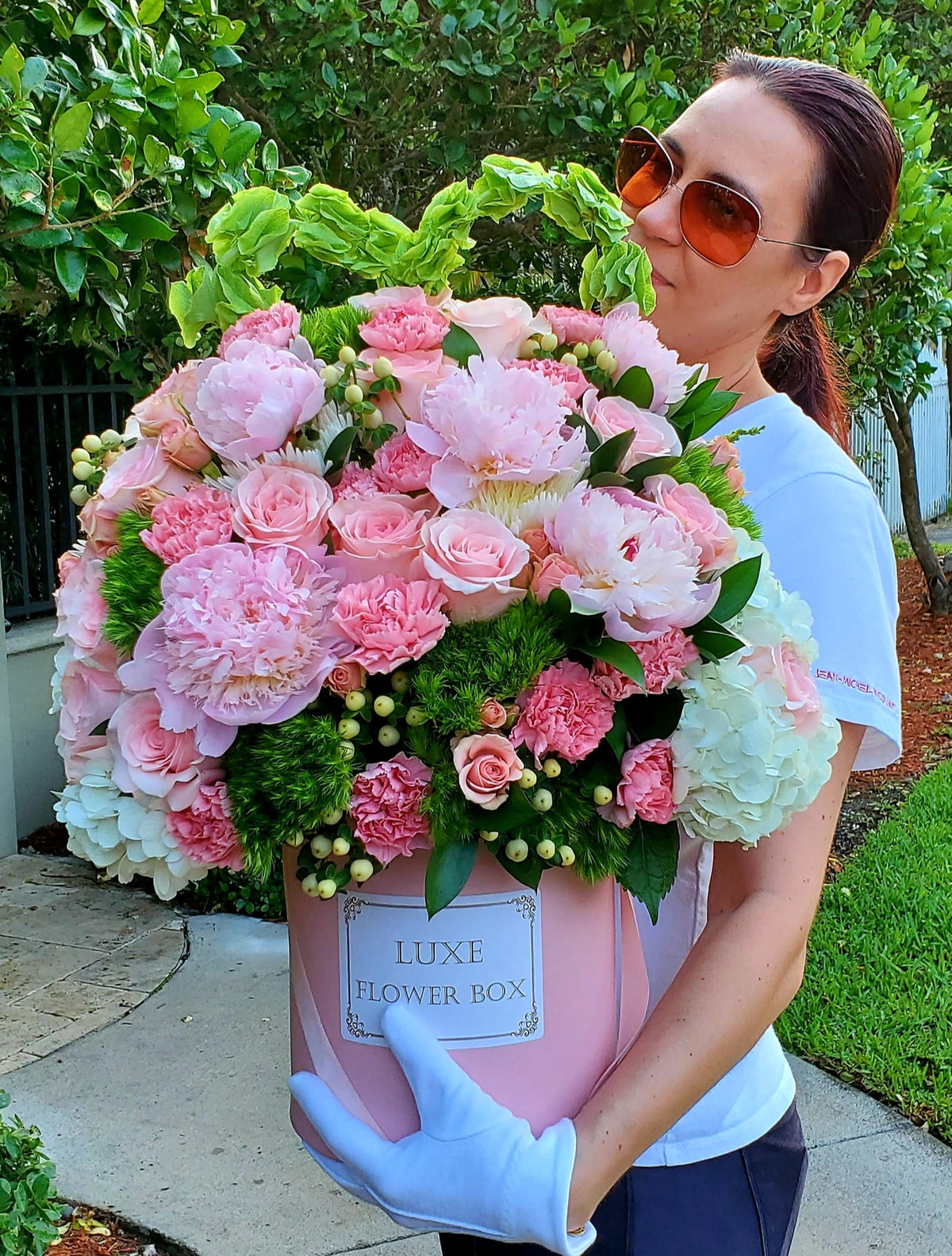A charming flower box named "Malvina," featuring a delicate mix of peonies, roses, spray roses, and carnations in soft, romantic hues, creating a graceful and elegant arrangement perfect for any occasion.