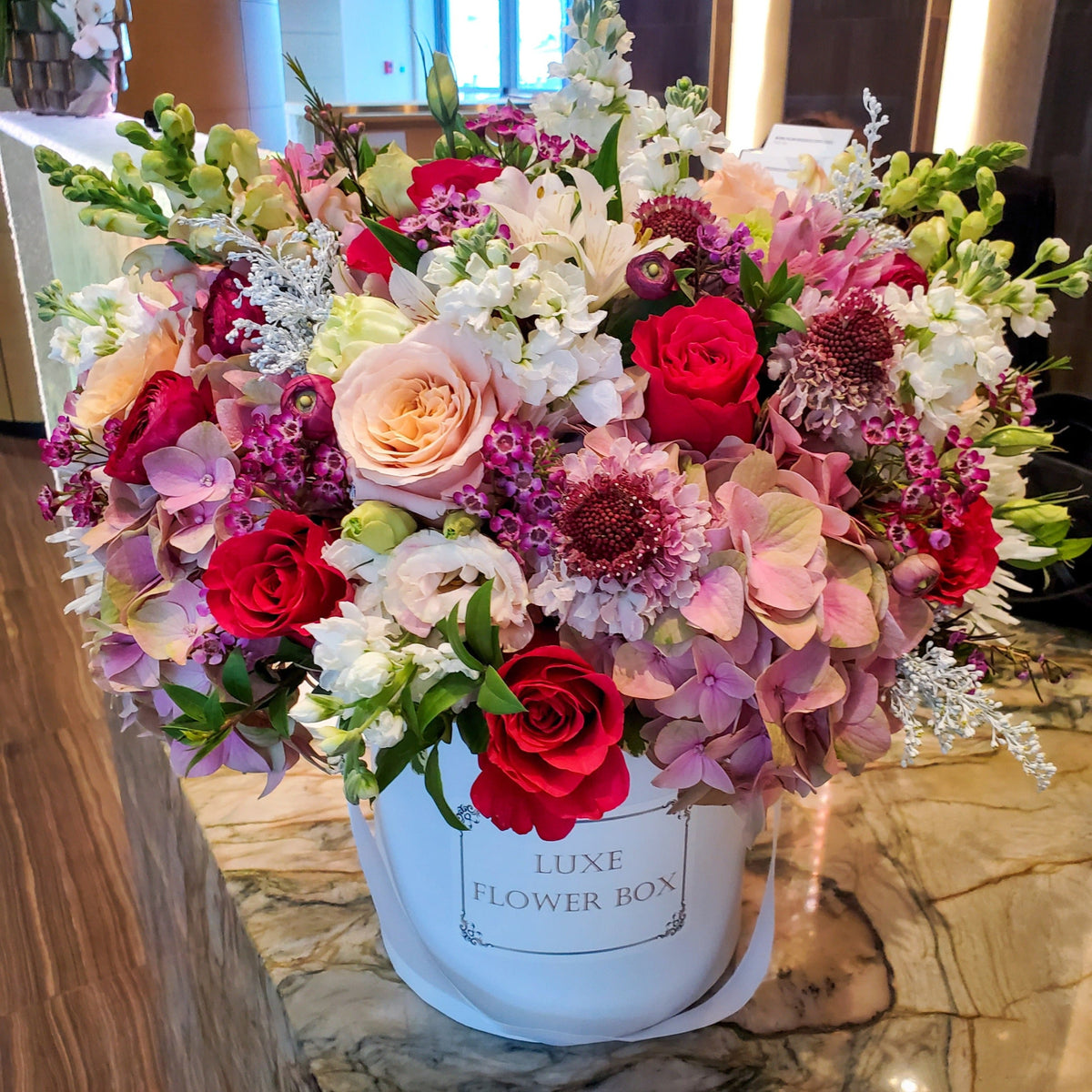 A chic flower box featuring a stylish arrangement of hydrangeas, roses, and ranunculus, perfectly capturing a sophisticated and expressive mood for any occasion.