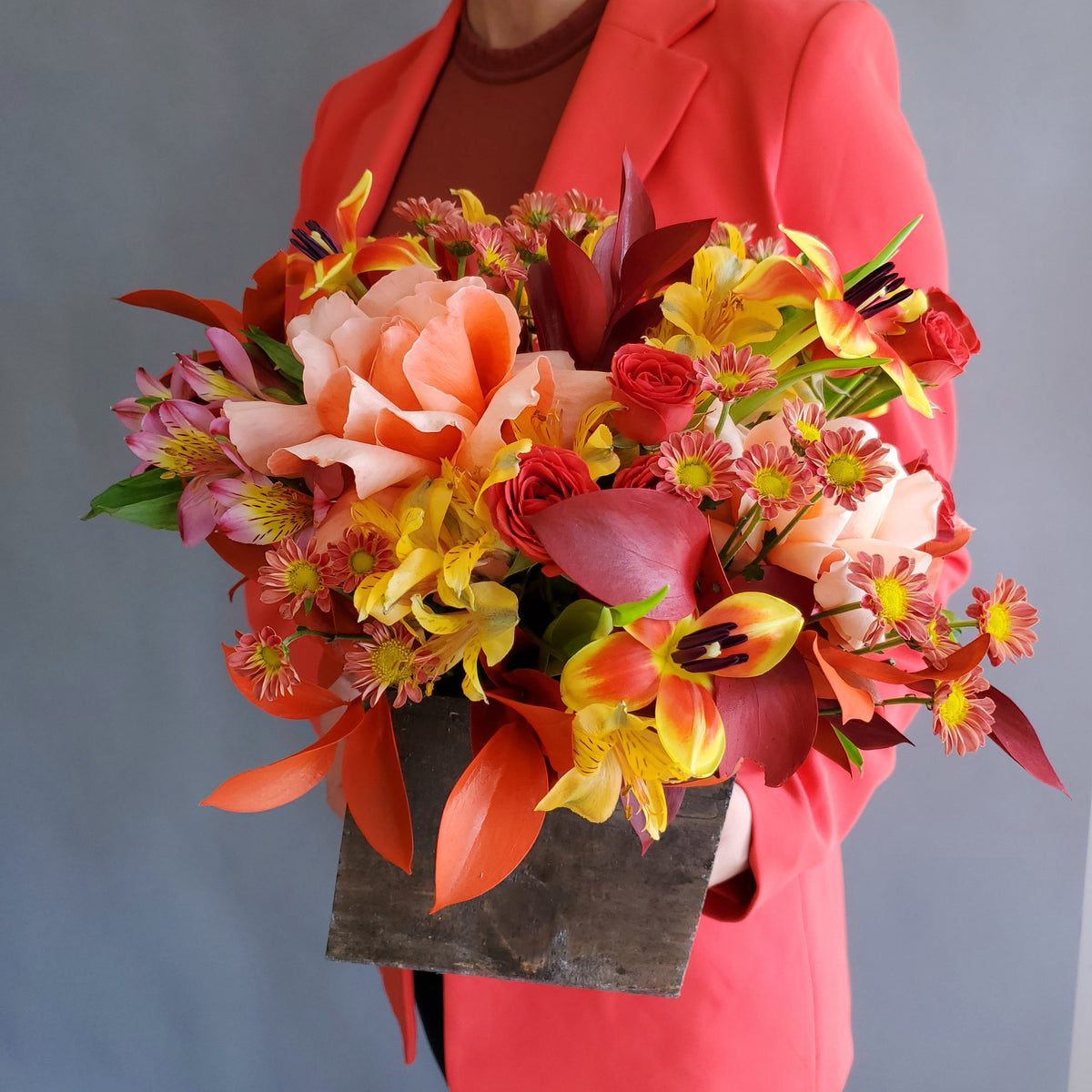 Person wearing a vibrant floral headpiece against a plain background