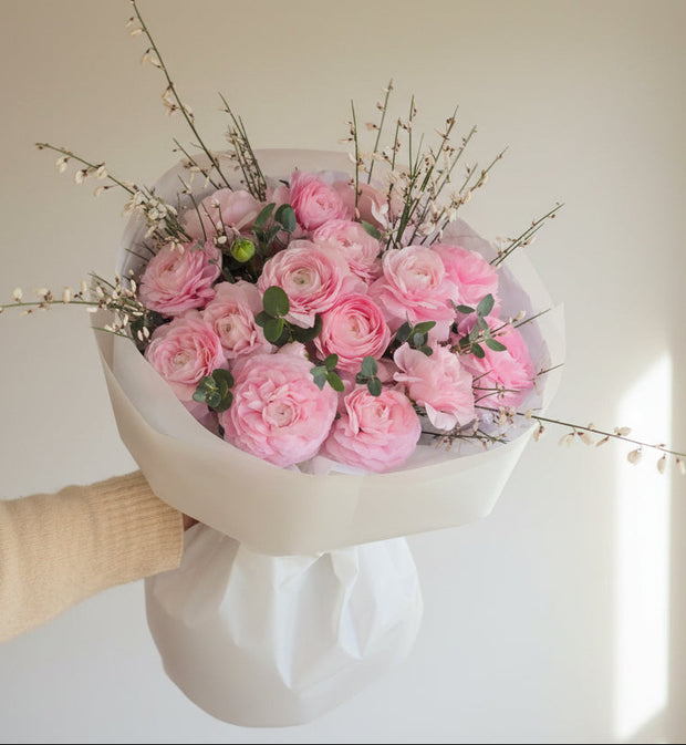 Pink Ranunculus, Genista, eucalyptus bouquet with soft pink flowers and greenery.