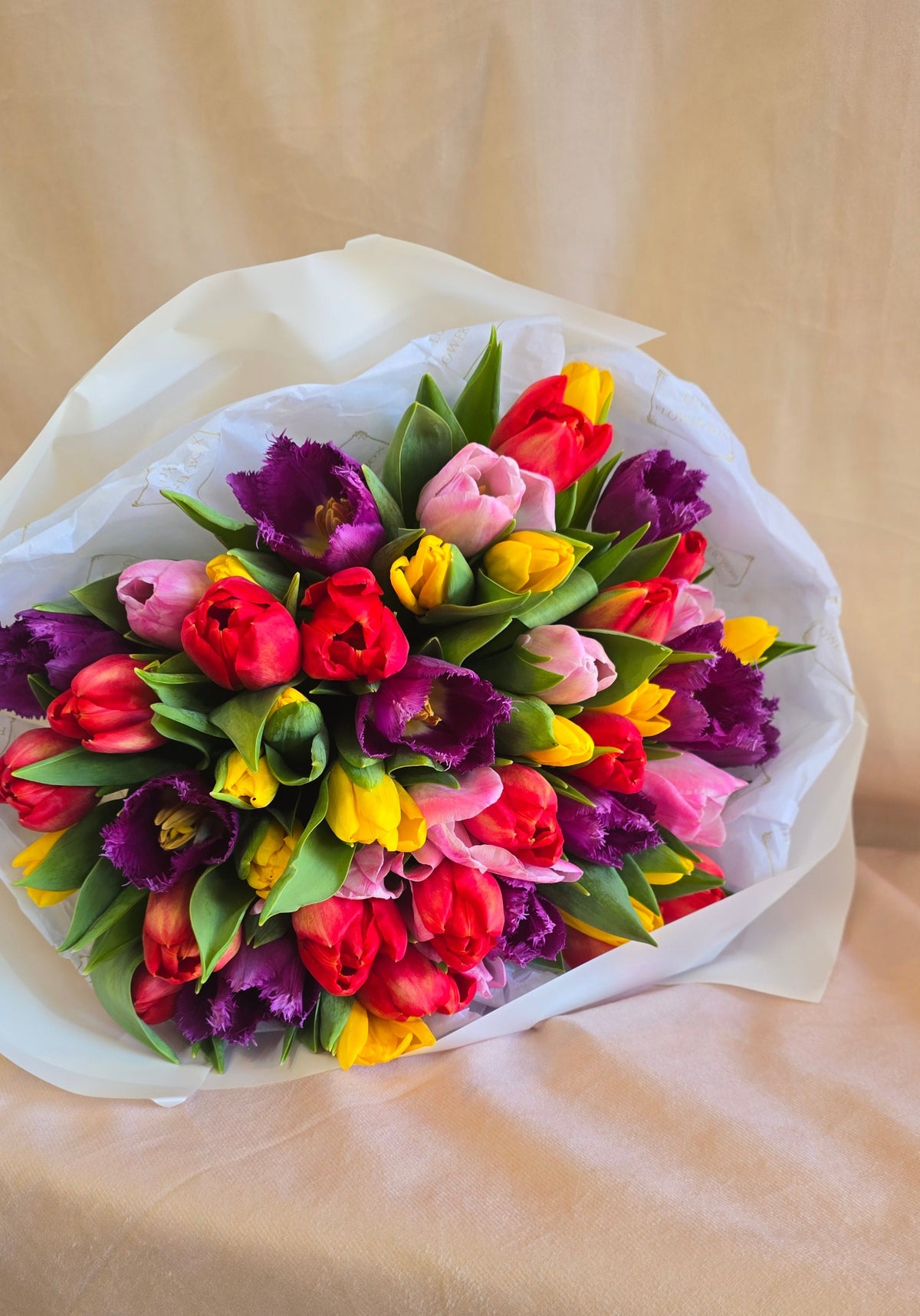 Bouquet of colorful tulips on a beige background