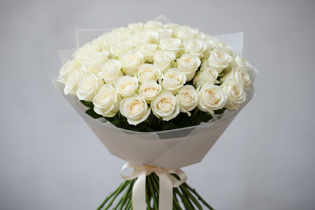Bouquet of white roses wrapped in paper with a ribbon 